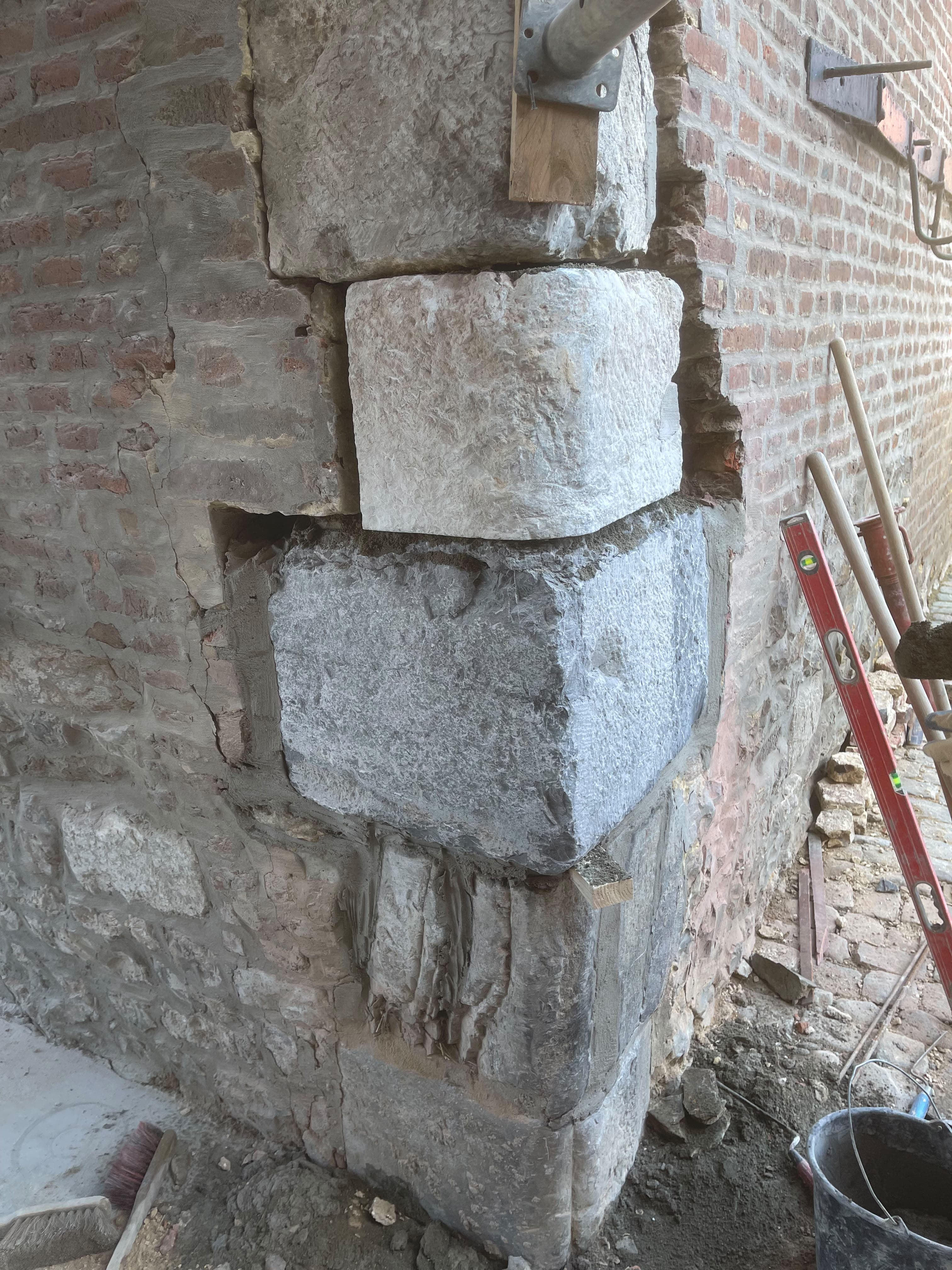 Angle de mur en briques et pierres de taille en cours de restauration