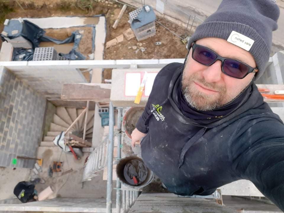 Artisan de l’équipe sur un chantier de rénovation, cage d’escalier en contrebas