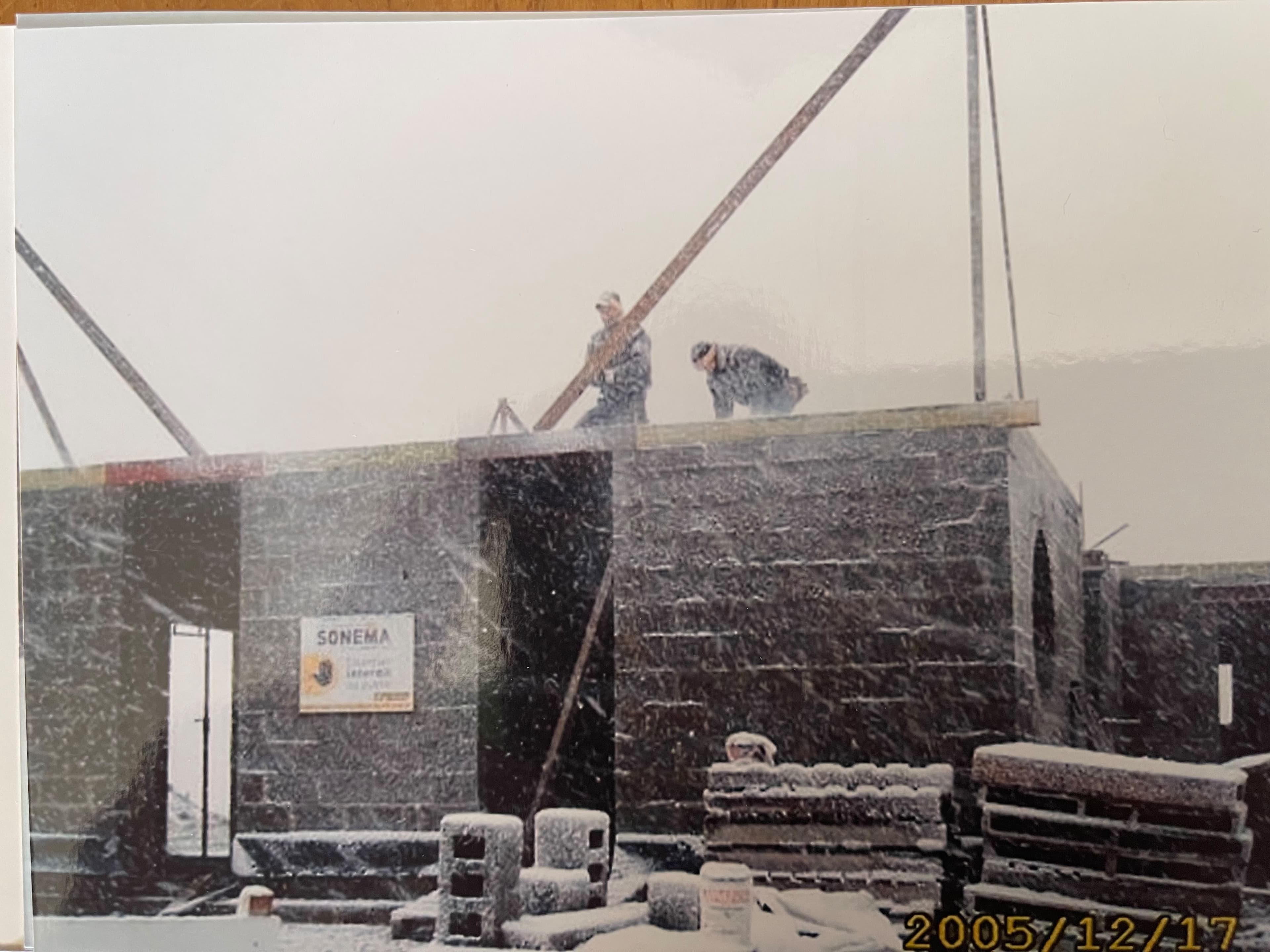 Artisans montant un mur en blocs sur un chantier