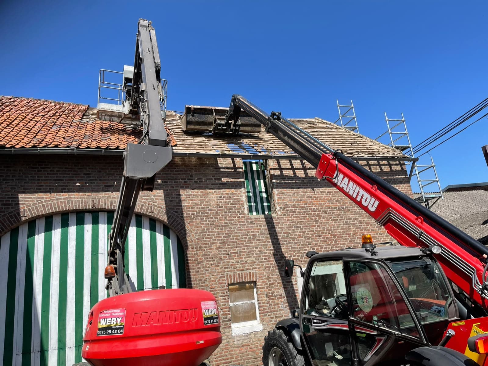 Chargeur télescopique levant des matériaux sur le toit d’une maison en briques