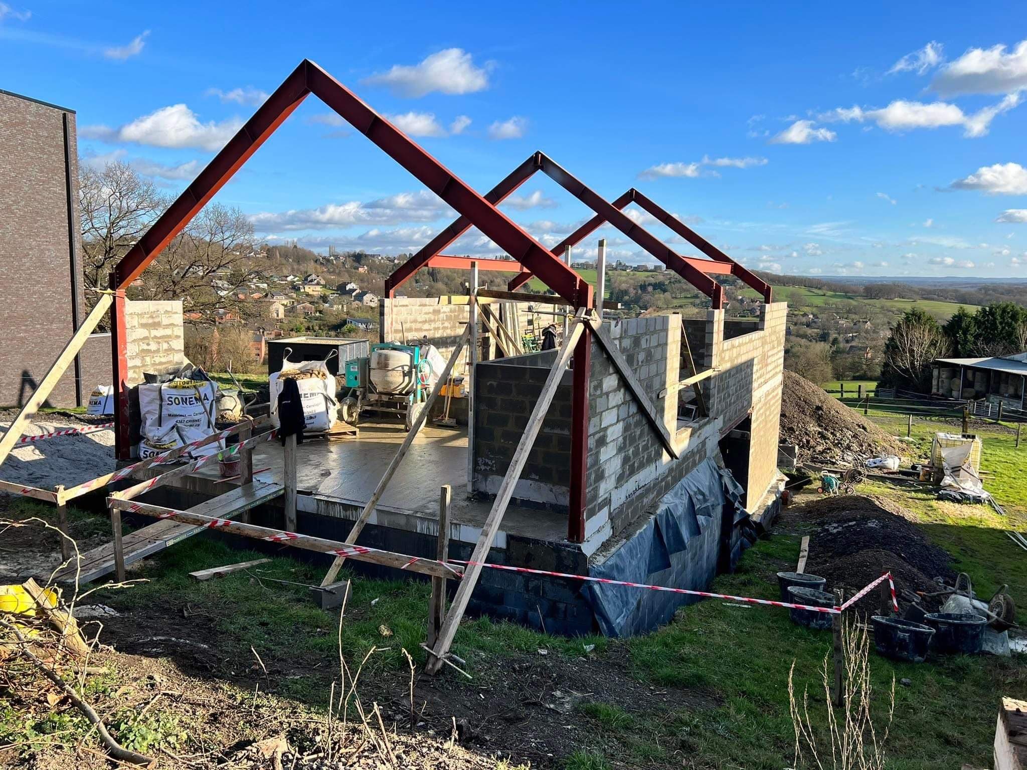 Charpente d’une maison neuve en cours de construction, avec vue sur la campagne