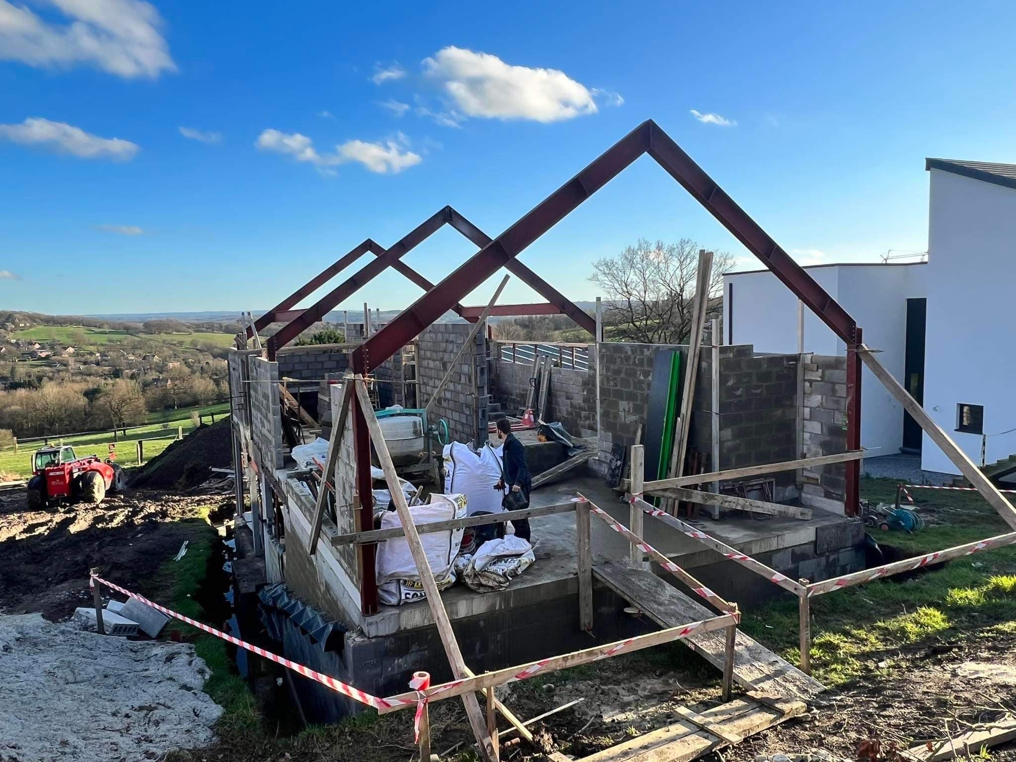 Charpente métallique d’une maison en construction, vue sur la campagne