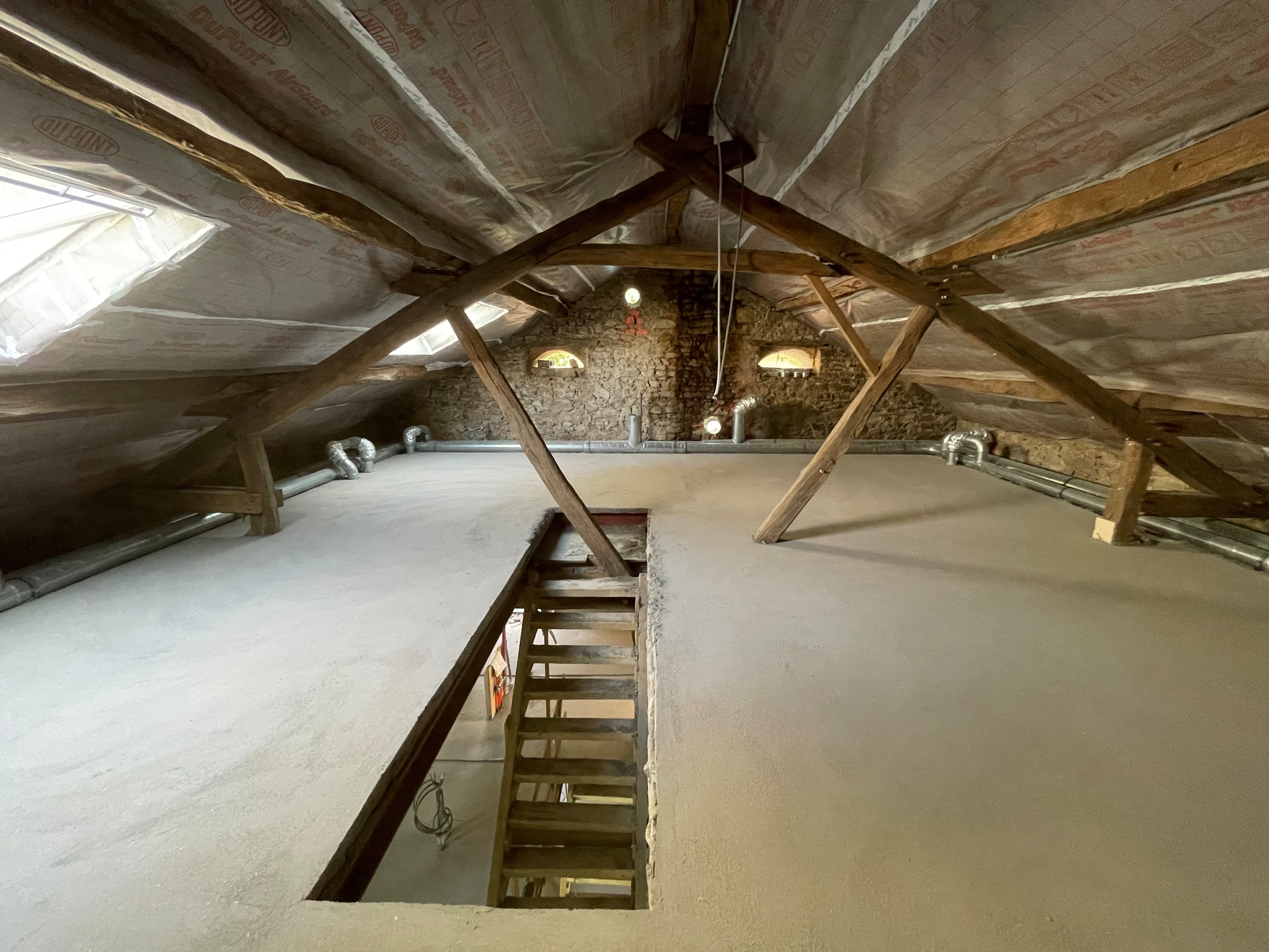 Combles sous une charpente en bois ancienne, en cours de rénovation