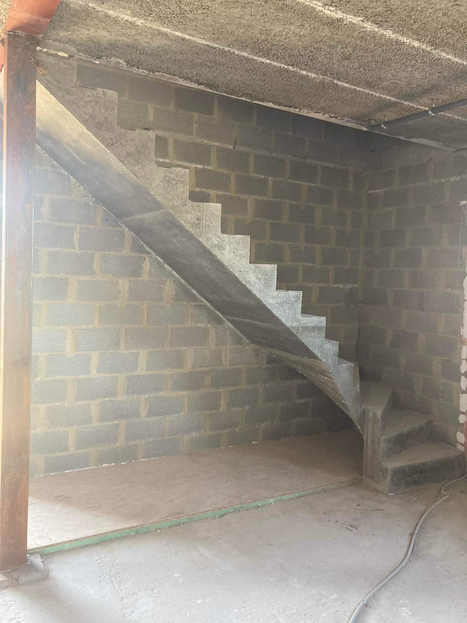 Escalier en blocs maçonné dans une pièce en chantier