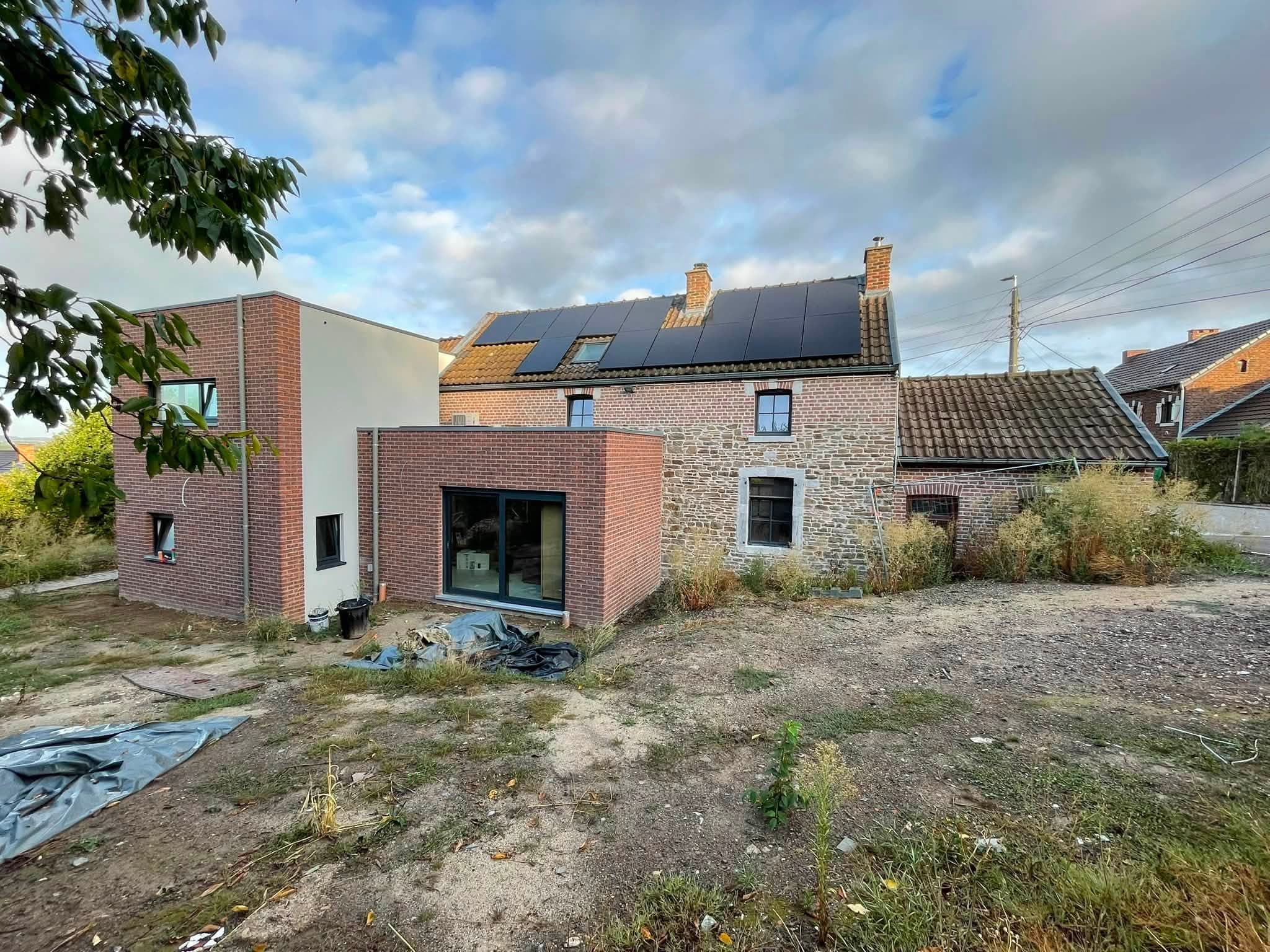 Extension contemporaine en brique à l’arrière d’une maison en pierre