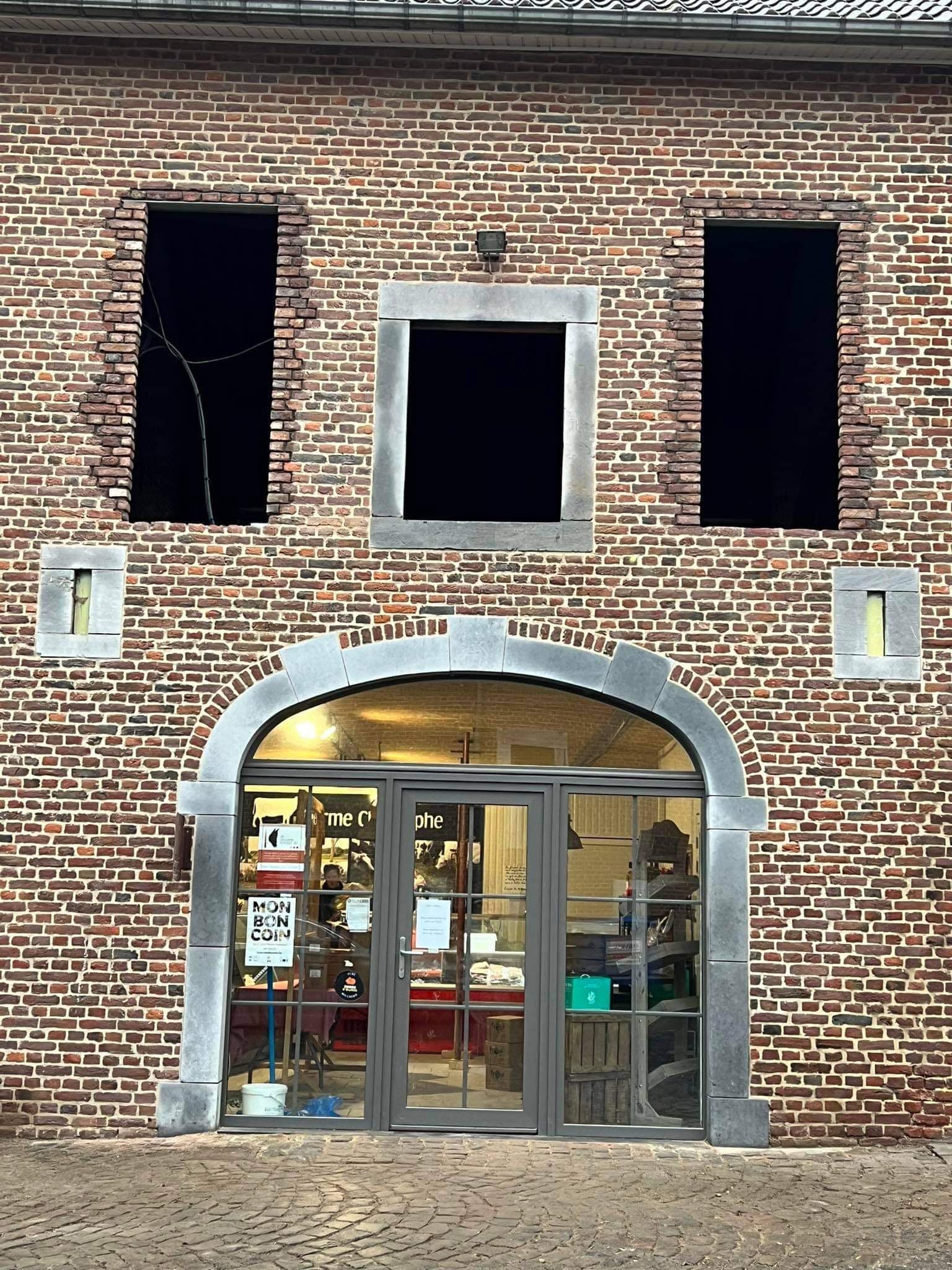 Façade en brique avec arche et encadrements en pierre bleue