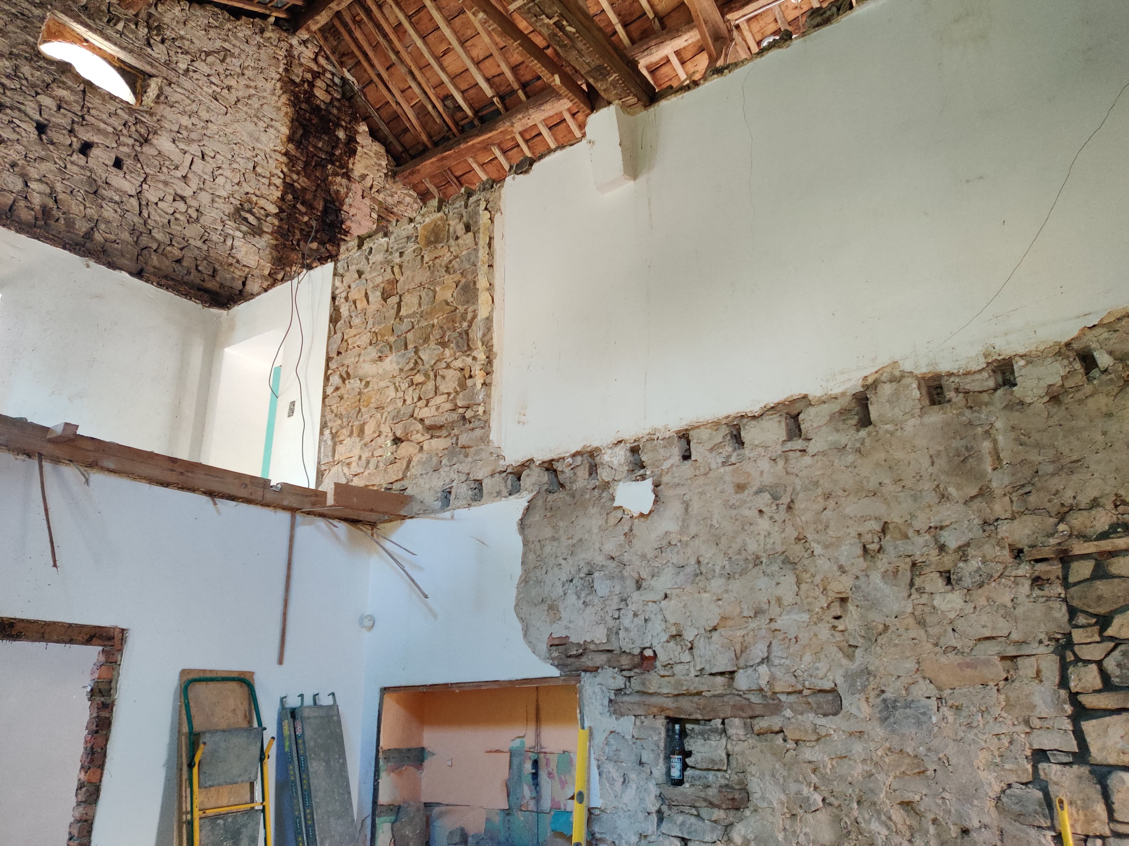 Mur en pierre mis à nu dans une pièce en rénovation