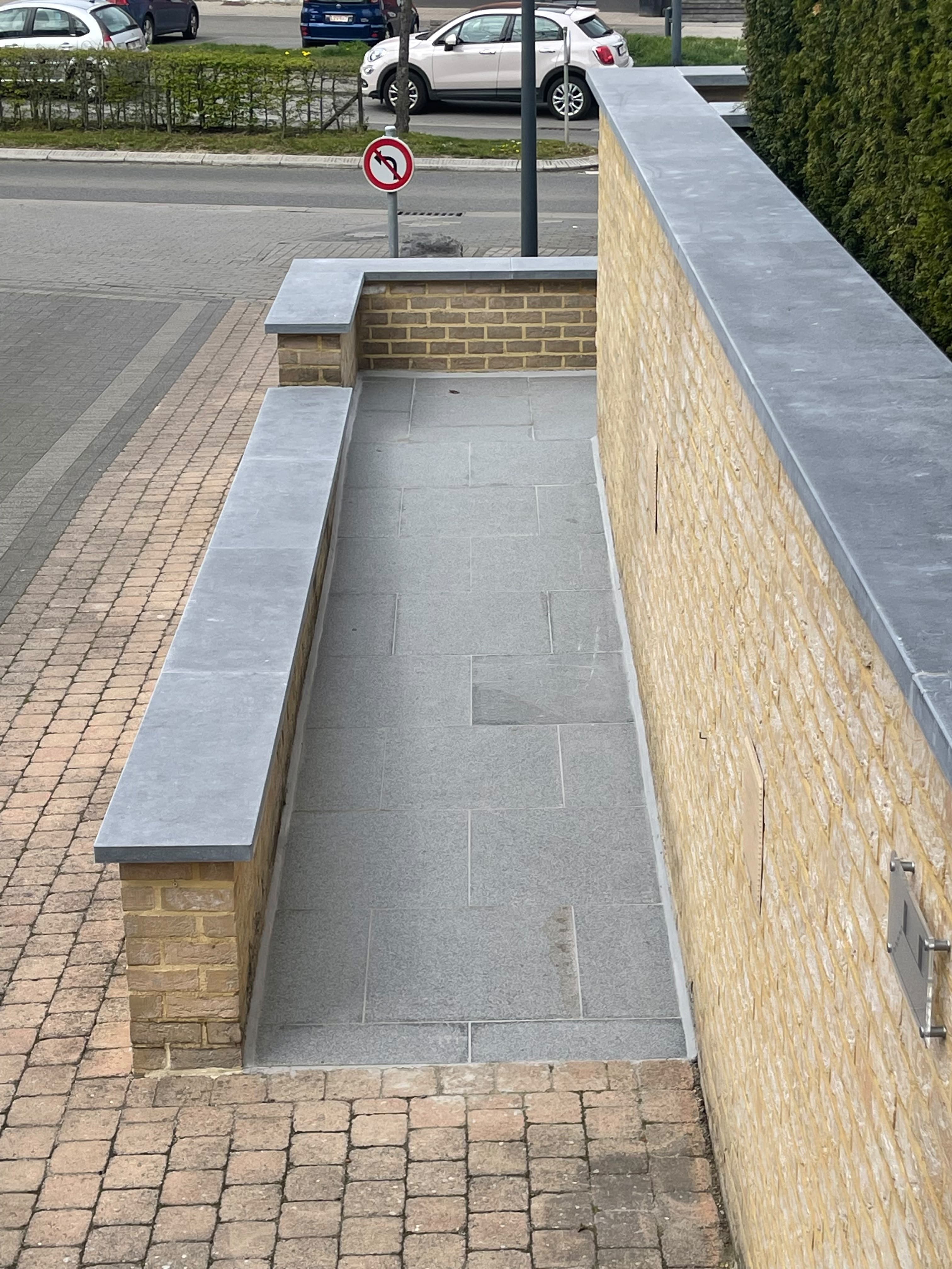 Muret maçonné et couvre-murs en pierre le long d’une allée pavée