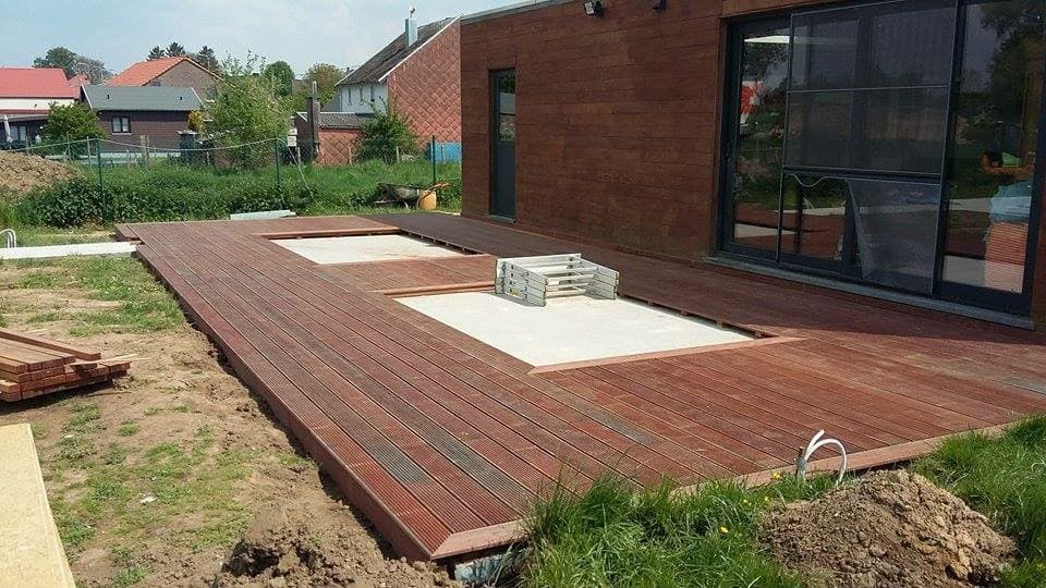 Structure d’une terrasse en bois devant une maison en brique